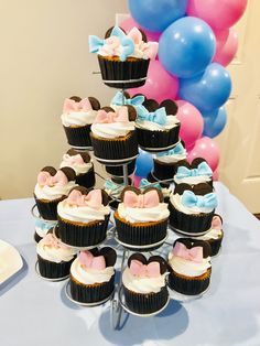 a table topped with lots of cupcakes covered in frosting and bow ties