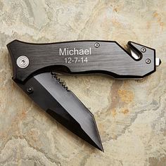 a knife with the name michael on it is laying on top of a stone wall