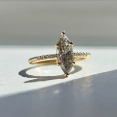 a yellow gold engagement ring with a pear shaped diamond