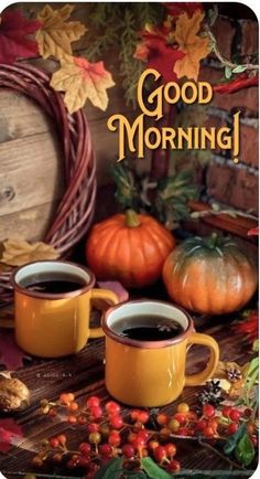 two cups of coffee sitting on top of a table next to pumpkins and leaves