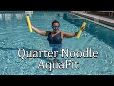 a woman standing in a swimming pool holding two large yellow poles with the words quarter noodle aquafit on it