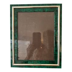 a green and gold frame sitting on top of a table