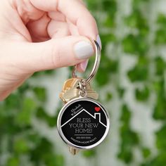 a person holding a keychain that says, blessing your new home on it