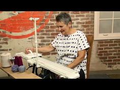 a woman is working on a piece of art with an electric sewing machine in front of her