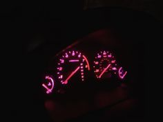 the speedometer is lit up in the dark with red light on it's face