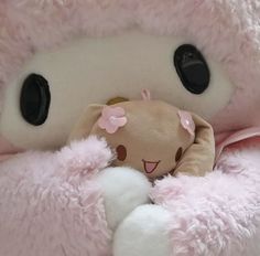 a pink teddy bear wrapped in a blanket