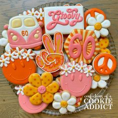 decorated cookies in the shape of animals and flowers on a plate with words that say 50