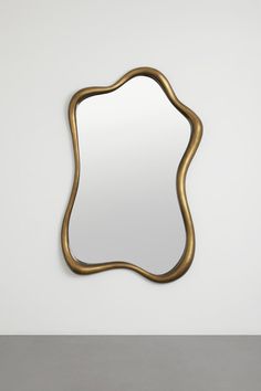 a mirror that is sitting on top of a table in front of a white wall