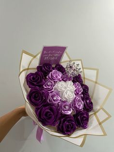 a purple and white rose bouquet with a tiara