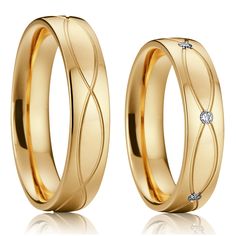 two gold wedding rings with a diamond in the middle