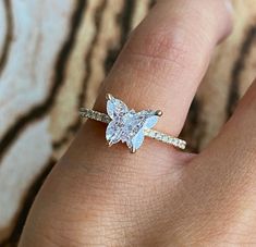 a woman's hand with a diamond ring on top of her finger and an engagement band