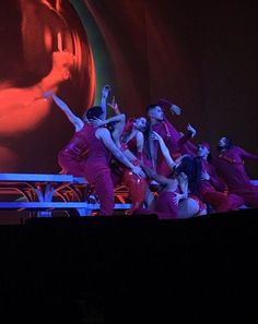 a group of women in red outfits on stage