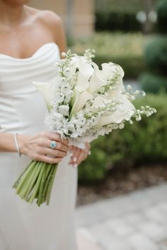 a woman holding a bouquet of white flowers