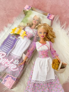 a barbie doll laying on top of a bed next to a package of cookies and cereal