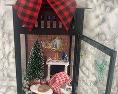 a doll house with furniture and decorations on the table in front of it is decorated for christmas