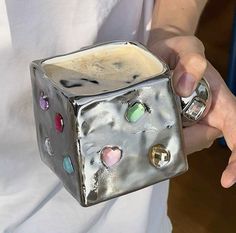 a close up of a person holding a metal object with hearts on it's side