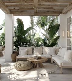 an outdoor living room with white furniture and plants