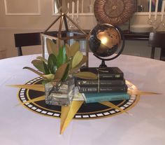 a table topped with books and a vase filled with plants