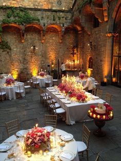 an indoor dining area with tables and chairs set up for formal function, lit by candles