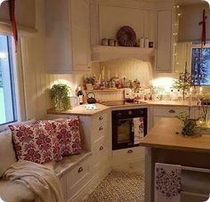 a kitchen filled with lots of counter top space and white cabinets next to a window