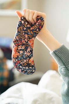 a person holding up a pair of socks in the air with their hands on top of them