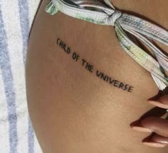 a woman's thigh with the words end of the universe written on it and a ribbon tied around her waist