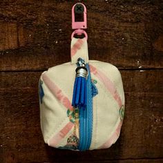 a small purse with a blue tassel hanging from it