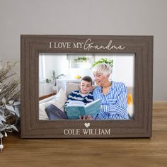 a wooden frame with the words i love my grandma and a photo of an older woman reading a book