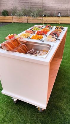 an outdoor buffet is set up on the grass