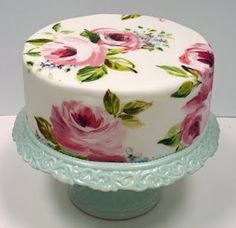 a white cake with pink flowers on it and the words feliz anniversaro