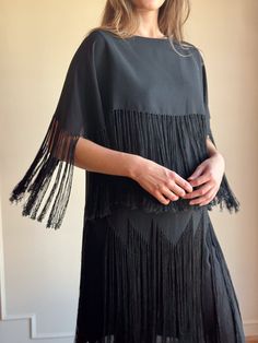 "This is a whimsical sheer black party dress from the 50's (or earlier).  Extra long, dramatic fringe, semi sheer acetate material and shapeless silhouette.  A perfetly preserved older piece that is both fun and unique.  No tags Acetate Bust- 38\" Waist- 40\" (Boxy fit Medium) Length- 42\" Excellent condition - please note, this is sheer, single stich, pulls over the head with no fastens / zippers" Evening Flapper Dress With Tassels For Party Season, Evening Dresses With Tassels For Party Season, Chic Fringe Flapper Dress For Party Season, Elegant Fringe Dress For Costume Party, Evening Fringe Dress For Party Season, Spring Cocktail Flapper Dress With Fringe, Chic Evening Flapper Dress With Fringe, Evening Flapper Dress With Fringe For Party Season, Black Beaded Fringe Flapper Dress For Cocktail