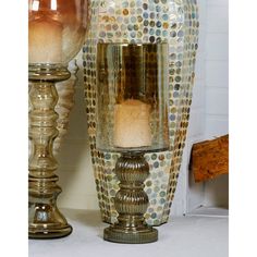 two vases sitting next to each other on a table with one candle in it