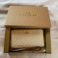 Nwt White Embossed Coach Wallet / Wristlet In White With Gold Hardware With Gift Box! This Comes With Two Interchangeable Wristlet Straps; 1 In Matching White And The Other In Beige With Two Charms. 1 Charm Is A Flower That Says Coach, The Other A Tag That Says Coach. You Can Choose To Use Neither And Use It As A Wallet. Zippered Closure. It Features 5 Open Pockets Inside For Cash, Receipts Etc., It Has 1 Zippered Pocket For Coins And 12 Slots For Id, Credit Cards, Loyalty Cards And Business Car Beige Wallet With Original Box As Gift, Gold Wallets With Original Box For Gift, White Rectangular Case Clutch As Gift, White Rectangular Case Clutch For Gift, White Rectangular Clutch For Gifts, Luxury White Wallets For Gifts, Luxury White Wallet Perfect For Gift, Luxury White Coach Wallet, Elegant White Clutch With Card Slots