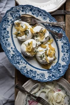 two plates with deviled eggs and silverware on them