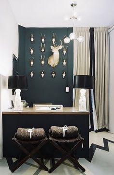 two stools in front of a desk with deer heads on the wall