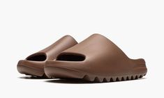 The adidas Yeezy Slide “Flax” is another versatile, earth tone colorway of Kanye West’s casual slip-on sandal.  Ye’s penchant for neutral colored Yeezys continues on the Yeezy Slide in “Flax,” a versatile, autumn-inspired look for one of the most popular shoes in the adidas Yeezy line.  The “Flax” features a brown-colored lightweight EVA foam construction that provides optimal comfort.  The midfoot arch stabilizes the foot and the ridged outsole ensures stability and grip on slippery surfaces. Kanye West Yeezy Slides, Shoes Yezzy Slides, Kanye West Shoes Yeezy, Brown Yeezy Slides, Yeezy Slides Desert Sand, Adidas Yeezy Slides, Yeezy Slides Pure, Adidas Yeezy Slide, 70s Converse