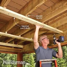 a man is working on the roof of his house with a driller and hammer