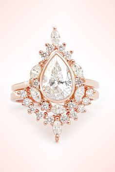 a pear shaped diamond engagement ring set in 18k rose gold with diamonds surrounding it