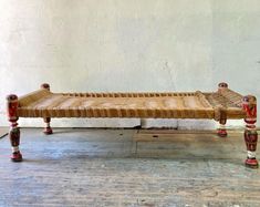 a wooden bed sitting on top of a hard wood floor next to a white wall