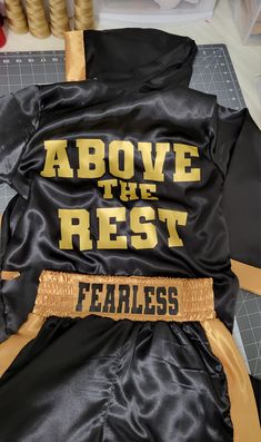 a black and gold jacket with the words above it that reads above the rest fearless