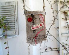 a piece of cloth hanging from a tree branch with the word love written on it