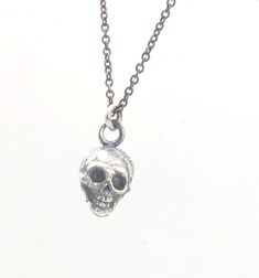 This solid sterling silver Skull Pendant is wax carved by hand and cast using the ancient process of Lost Wax casting. I then made a mold, which I can inject with wax and make wax copies of the Jolly Roger Pendant and cast a lot of them for all y’all! Once cast, I clean them up, polish, texture, and then oxidize the background and polish the skull and bones.These Skull Pendants are available alone or with a shiny or oxidized sterling silver cable chain in several lengths.This Skull Pendant is pa Silver Skull Necklace With Adjustable Chain, Adjustable Silver Skull Necklace, Silver Skull Chain Necklace, The Jolly Roger, Sterling Silver Skull Necklace, Silver Oxidized Skull Necklace, Wax Carving, Jolly Roger, Line Shopping