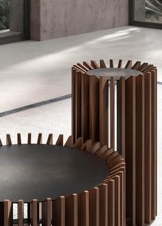 two tables with wooden slats on them in front of an open window and concrete floor