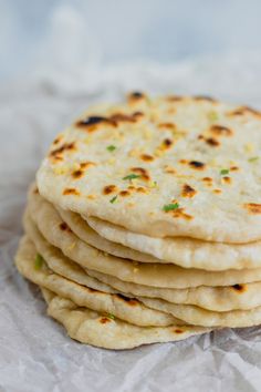 a stack of pita bread sitting on top of a piece of white wax paper