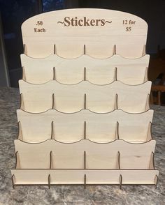 a wooden rack with six sections for stickers on it sitting on a counter top