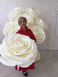 a woman holding a giant bouquet of white roses