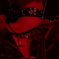 a close up shot of a woman's neck wearing a red light necklace and choker