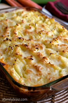 a casserole dish with potatoes and cheese in a glass baking dish on a wicker table