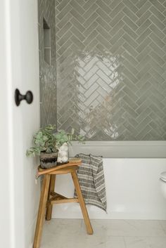 a small wooden stool sitting next to a bath tub