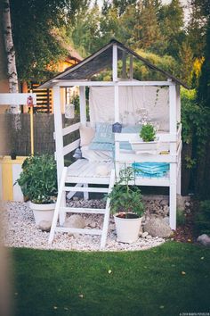 a white gazebo sitting on top of a lush green field